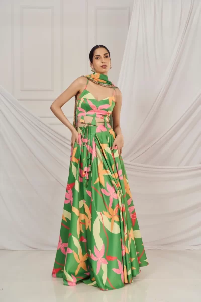 Leaf Green Floral Print Satin Silk Strappy Blouse paired with matching Box Pleat Lehenga and Printed Glitter Georgette Dupatta with Gold trim Lace Detail.