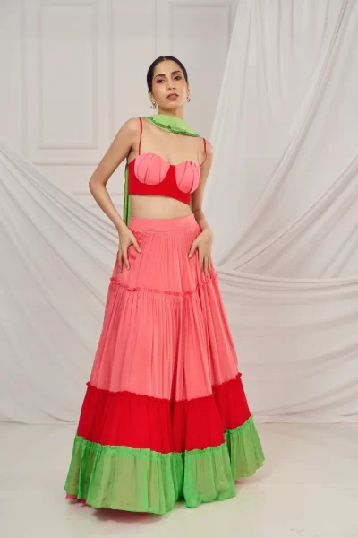 Red and Pink Ruched Crepe Blouse paired with Tiered Chinon Lehenga and Green Scallop Embroidered Crepe Dupatta